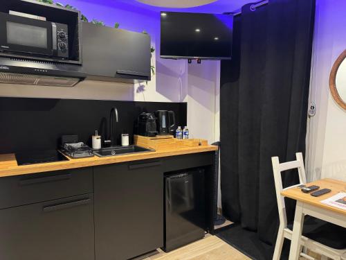 a kitchen with a counter top and a microwave at Suite Dream by Need'Amour in Pontault-Combault