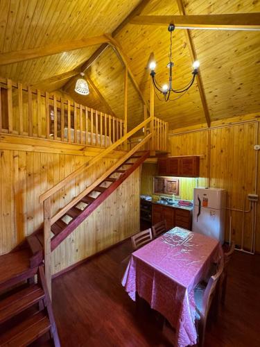 a dining room with a table and stairs in a cabin at Un rincon de paz in Colón
