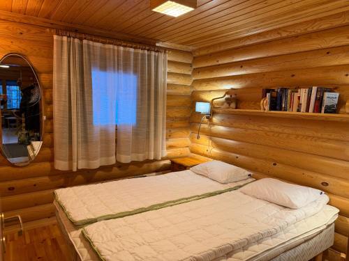 a bedroom with a bed in a log cabin at Villa Rukan Honka in Ruka