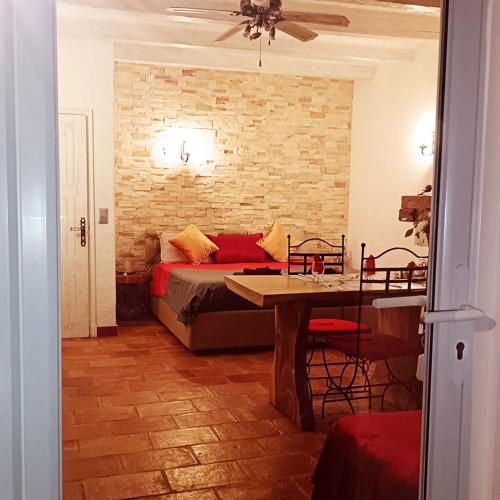 1 dormitorio con cama, mesa y pared de ladrillo en Féerie Love, en Puget-sur-Argens