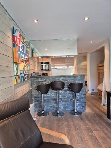 - un salon avec un bar avec deux tabourets dans l'établissement BEC 563 - Beautiful apartment T2 lake view, à Tignes
