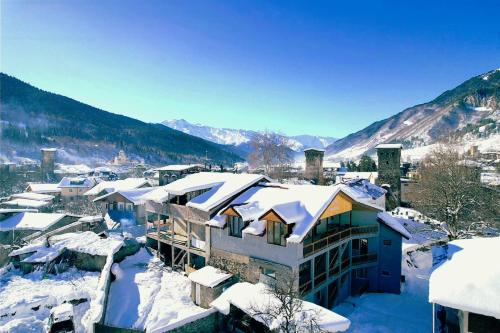 a town covered in snow with mountains in the background at Hotel Maria in Mestia