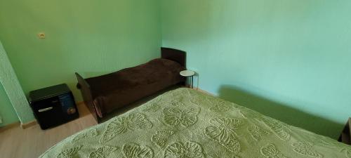 a bedroom with a bed with a green bedspread at Hotel Maria in Mestia