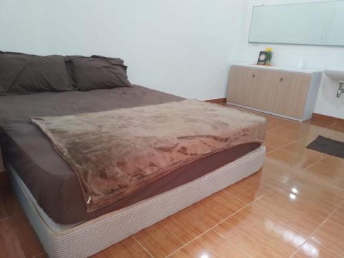 a bed in a room with a wooden floor at Homestay Syariah Bantul in Bantul