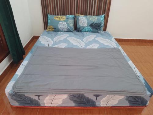 a large bed in a bedroom with blue pillows at Homestay Syariah Bantul in Bantul