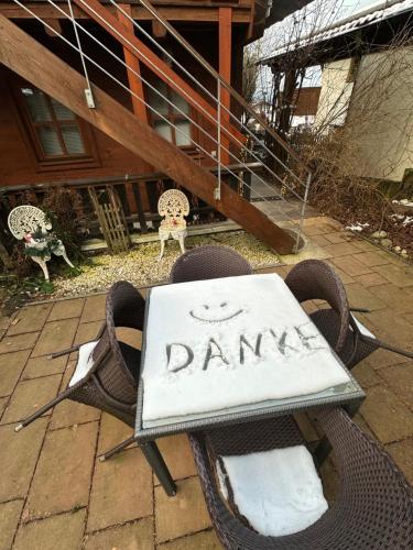 a sign that says damned sitting on chairs in a yard at Landhaus de Gaspary in Seehausen am Staffelsee