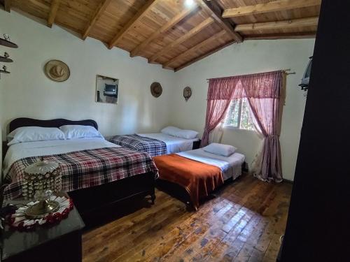 a bedroom with two beds and a window at Finca Villa Isaura, Carmen del Viboral in San Isidro