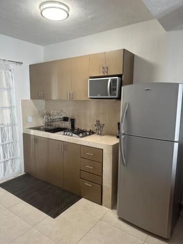 a kitchen with a refrigerator and a microwave at Casa Rivera Cancún in Cancún
