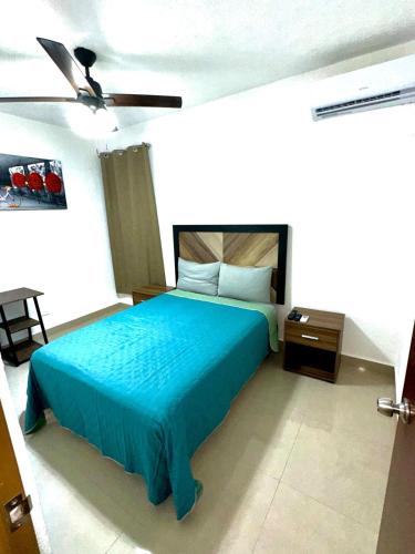 a bedroom with a blue bed and a ceiling fan at Casa Rivera Cancún in Cancún