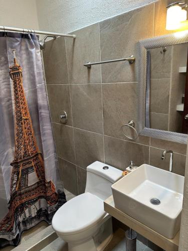 a bathroom with a toilet and a sink and the eiffel tower at Casa Rivera Cancún in Cancún