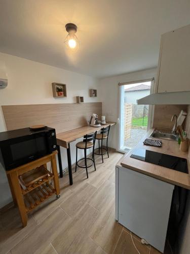 - une cuisine avec une table en bois et un comptoir dans l'établissement le Cocon des Vignes, cosy, climatisé, wifi, parking privé, à Tain-lʼHermitage