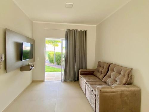 ein Wohnzimmer mit einer Couch und einer Glasschiebetür in der Unterkunft Condomínio Boas vistas in Aracati