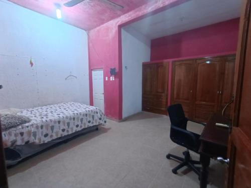 a bedroom with a bed and a desk and a chair at Casa de reyes in Tizimín