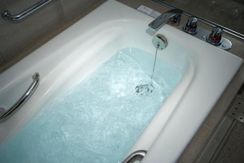 a bath tub with water pouring out of a faucet at The Prince Park Tower Tokyo - Preferred Hotels & Resorts, LVX Collection in Tokyo