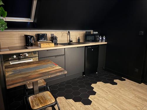 a kitchen with a counter with a sink and a table at Need'Amour - Suite chaleureuse in Pontault-Combault