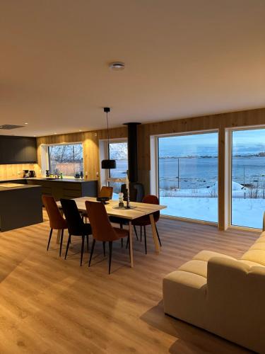 a kitchen and living room with a table and chairs at Lofoten Seaview apartment in Vestvågøya