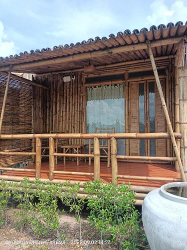 a wooden house with a fence and a porch at สวนเกษตรรักษ์ไผ่ Bamboo Conservation Farm in Surin