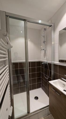 une salle de bain avec douche et lavabo dans l'établissement Immeuble Savonette, au Bourg-dʼOisans