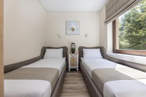 two beds in a room with a window at Lagūna - Šventoji in Šventoji