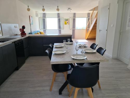 - une cuisine avec une table, des chaises et des verres à vin dans l'établissement 6-person apartment in sea view villa with jacuzzi, à San-Martino-di-Lota