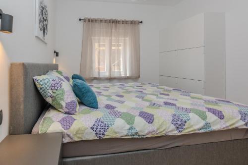 a bed with a quilt and pillows in a room at Villa Lucy Apartments in Vir