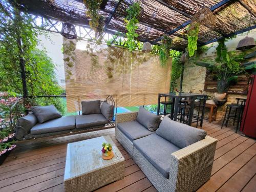 un patio avec des canapés et une table sur une terrasse dans l'établissement Le repere, à Villeneuve-lès-Béziers
