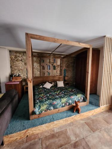 - une chambre avec un lit doté d'un cadre en bois dans l'établissement Le repere, à Villeneuve-lès-Béziers