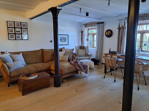 a living room with a couch and a table at Exklusives STALL-LOFT "ZUM PULVERER" - Naturdesign hinter historischen Mauern - AusZeit für 2 inmitten des Isarwinkels in Gaißach