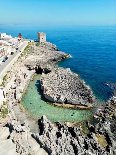 an aerial view of a rocky island in the ocean at L'Alba dei Sogni in Marina Serra