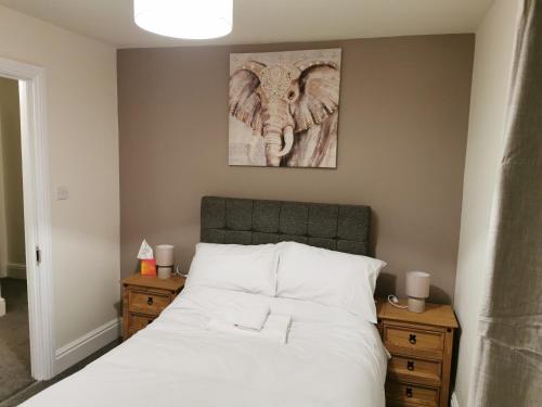a bedroom with a bed with an elephant picture on the wall at Family Friendly I Pets Welcome I Short Walk to Railway Station I 10min Drive to Safari Park in Kidderminster
