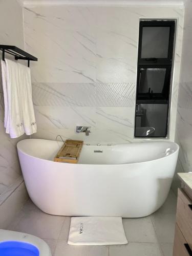 a white bath tub in a bathroom with a mirror at SuCasa Villa located in Maiyan Nanyuki in Nanyuki