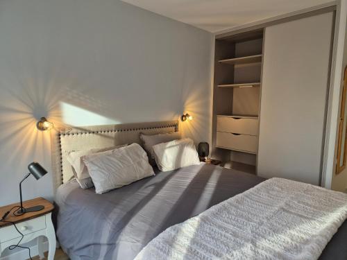 a bedroom with a bed with white sheets and pillows at Appartement cosy près du RER in Chessy
