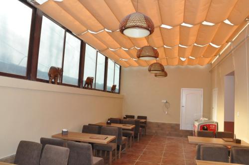 a dining room with tables and chairs and windows at Holly's Hostel in Chengdu