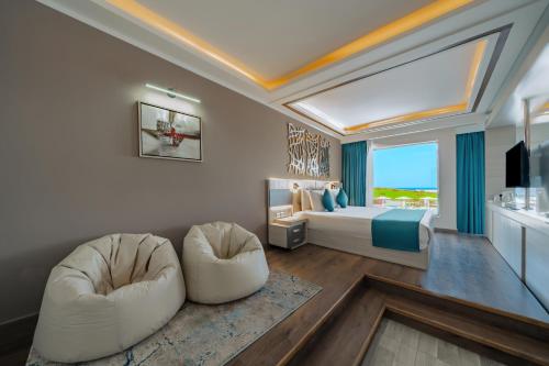 马萨阿拉姆SIRENA BEACH RESORT & SPA的一间有一张床和两把椅子的卧室
