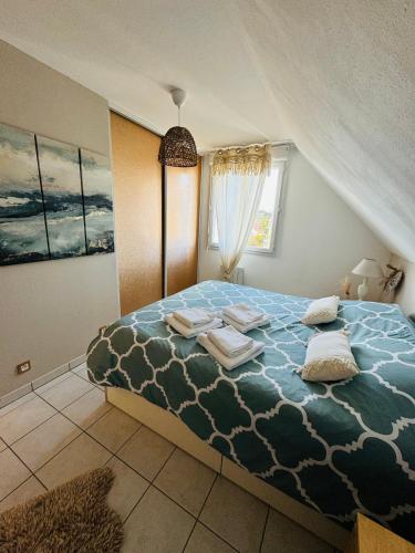 une chambre avec un grand lit avec des oreillers dessus dans l'établissement Le paillette T2 400 m de la plage Berck, à Berck-sur-Mer