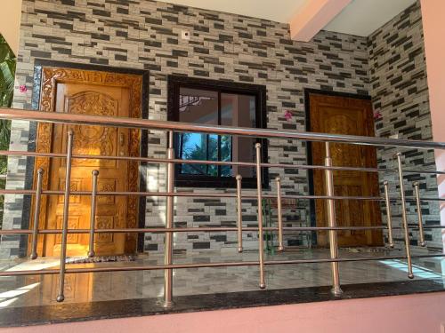 a balcony with a metal railing in front of two doors at Bethel Homestay Honnavar in Honāvar