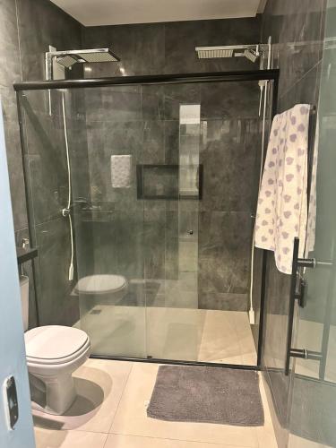 a bathroom with a shower and a toilet at Casa 108 in Guaibim