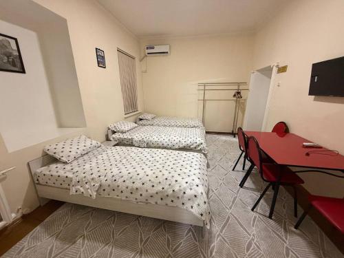 a room with two beds and a red desk at Avenue Guest House in Samarkand