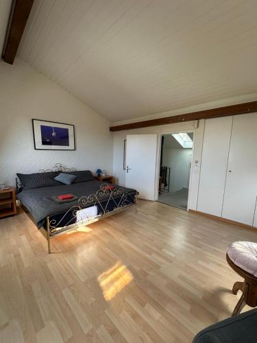 a bedroom with a bed and a wooden floor at Stilvolles Privatzimmer im Einfamilienhaus nahe Basel in Oberwil
