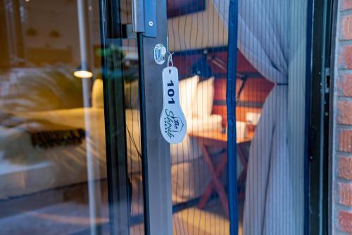 a glass door with a door tag on it at The Shrub Lodge in Victoria Falls