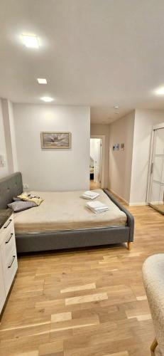 a bedroom with a large bed and a wooden floor at Apartamentai Gastrolės in Palanga