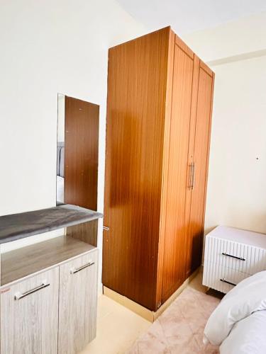 a bedroom with a wooden cabinet next to a bed at CM Homes in Kisii