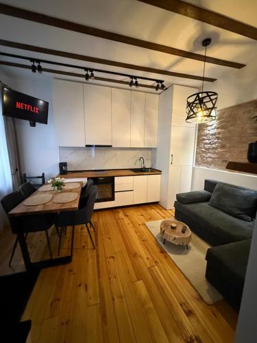a living room with a table and a kitchen at MMA's Apartment - 1 min de Târgul de Crăciun Sibiu in Sibiu