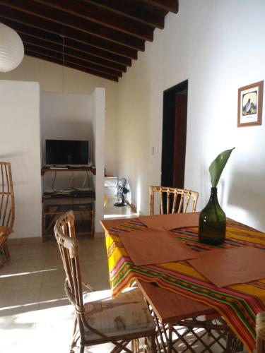 Un comedor con mesa y sillas y un televisor. en Arcadia, en Merlo