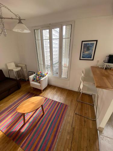- un salon avec une table et une table basse dans l'établissement Appartement de charme F2, Porte St Cloud, à Boulogne-Billancourt