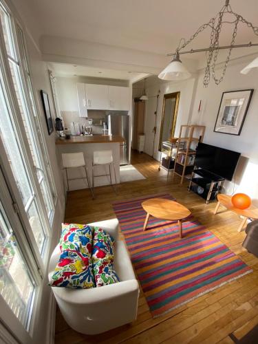 un salon avec un canapé et une table dans l'établissement Appartement de charme F2, Porte St Cloud, à Boulogne-Billancourt