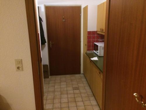 a kitchen with a door leading into a kitchen with a microwave at Grubhof in Sankt Martin bei Lofer