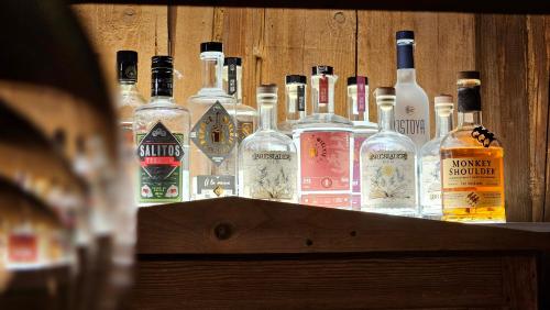 a group of bottles of alcohol on a wooden shelf at Hotel Protea Bolesławiec in Bolesławiec