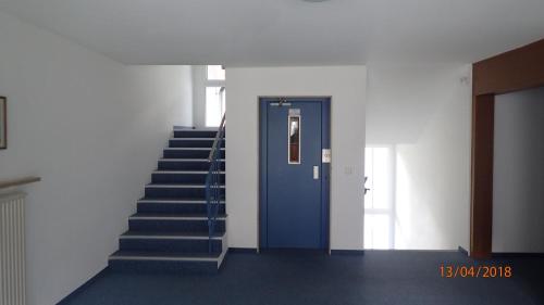 a stairway with a blue door and a blue staircase at Grubhof in Sankt Martin bei Lofer