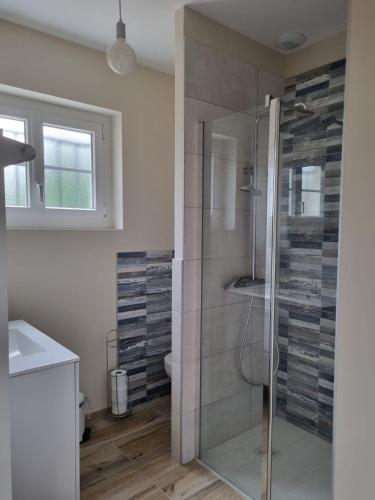 une salle de bain avec une douche en verre avec un lavabo dans l'établissement La maison du Bassin, 500 m de la plage à Andernos, à Andernos-les-Bains
